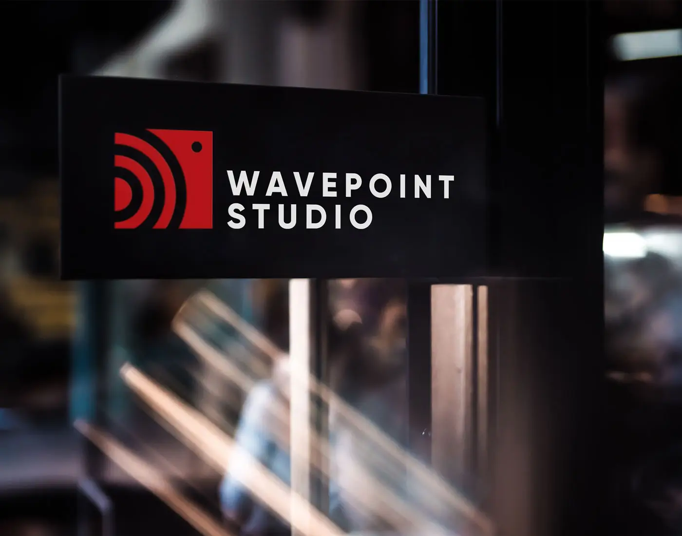 Sort skilt med Wavepoint Studio logo rød og hvid